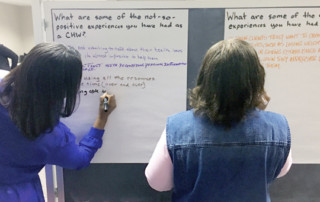 two women writing on posterboard